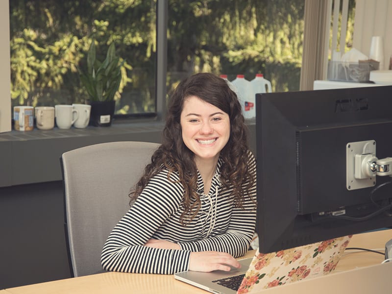 Student smiling while working at her computer.
