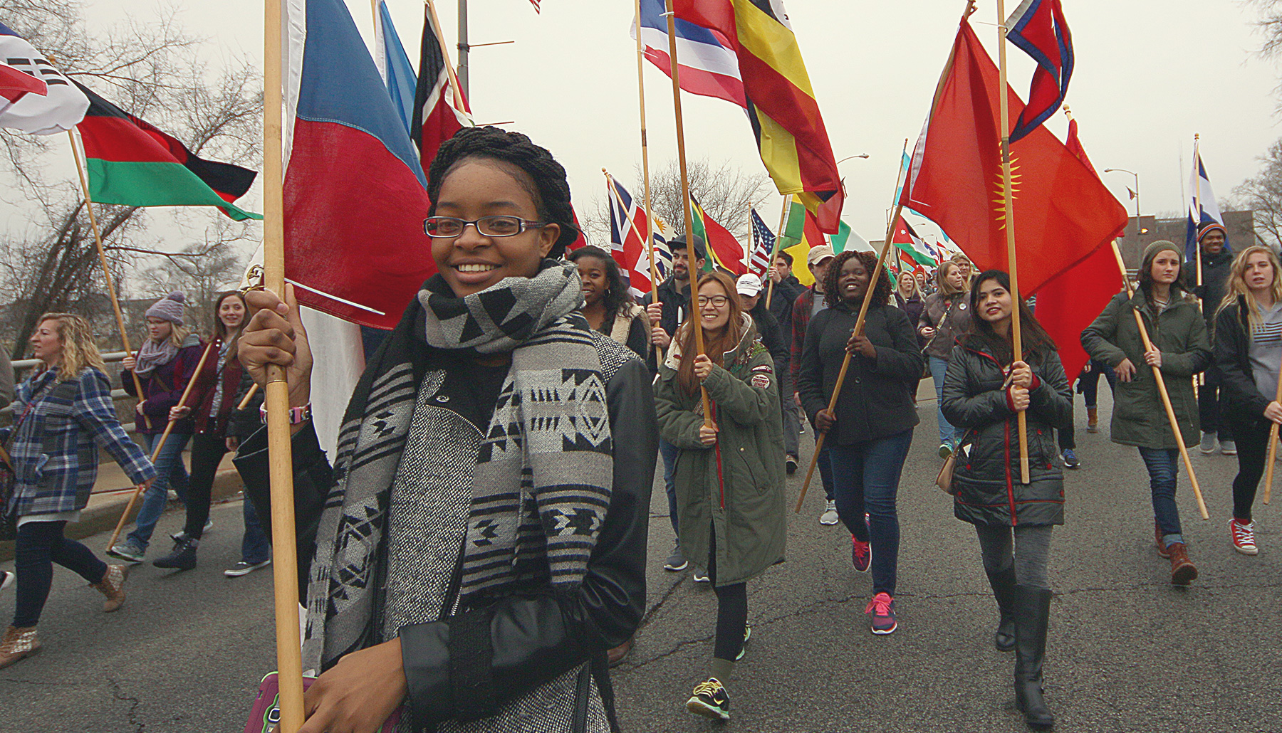 students march carrying international flags