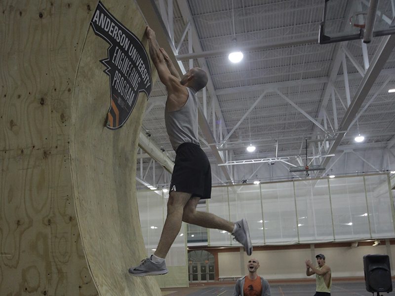 Student hanging onto the Warped Wall on the Ninja Warrior Course