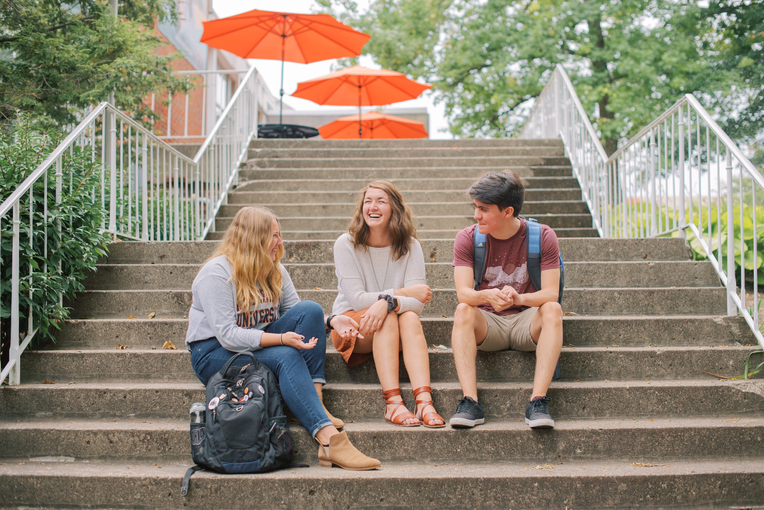 Two male students speaking with a female student outside of Byrum.