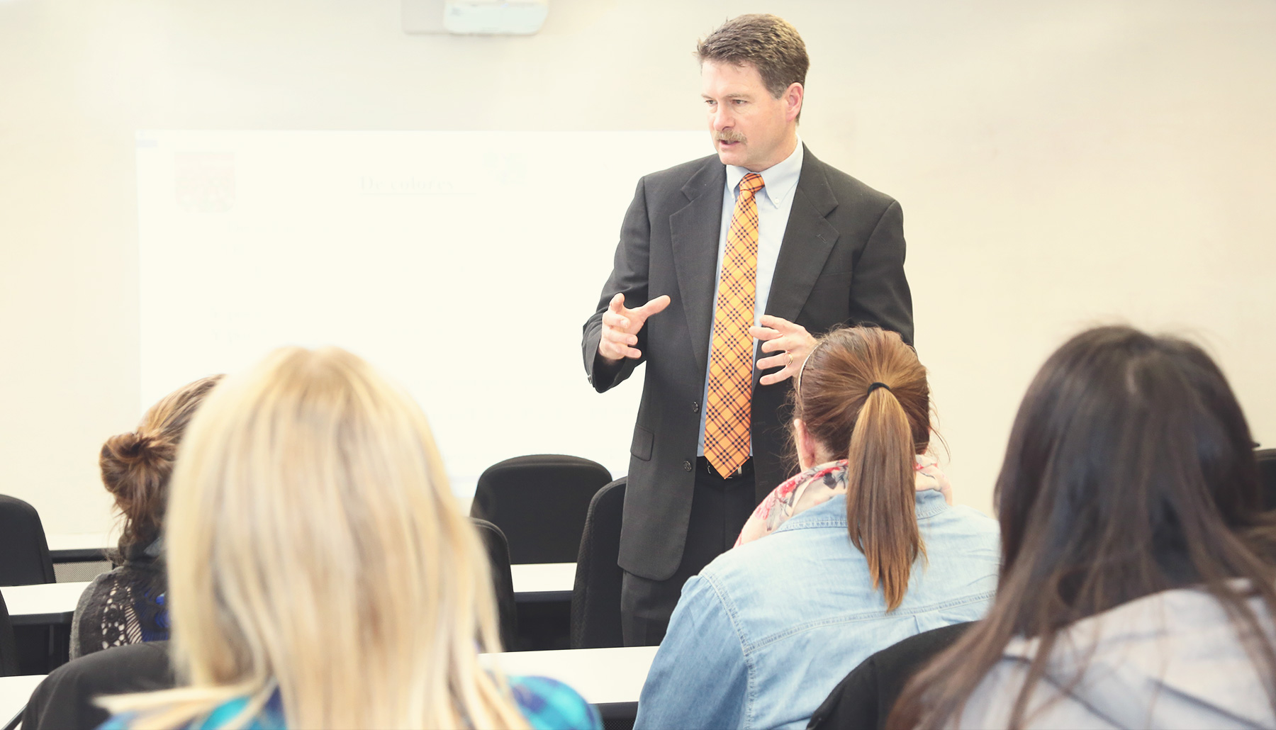 a male professor speaks to a class
