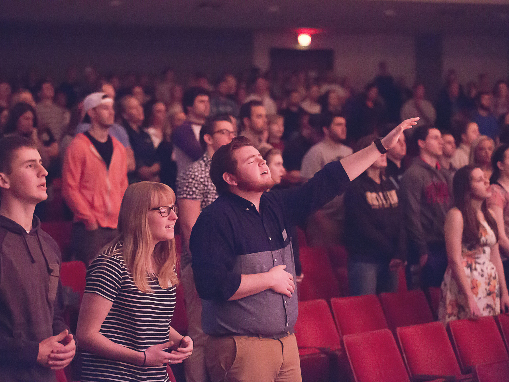 Chapel C view of worshippers during chapel singing and lifting hands