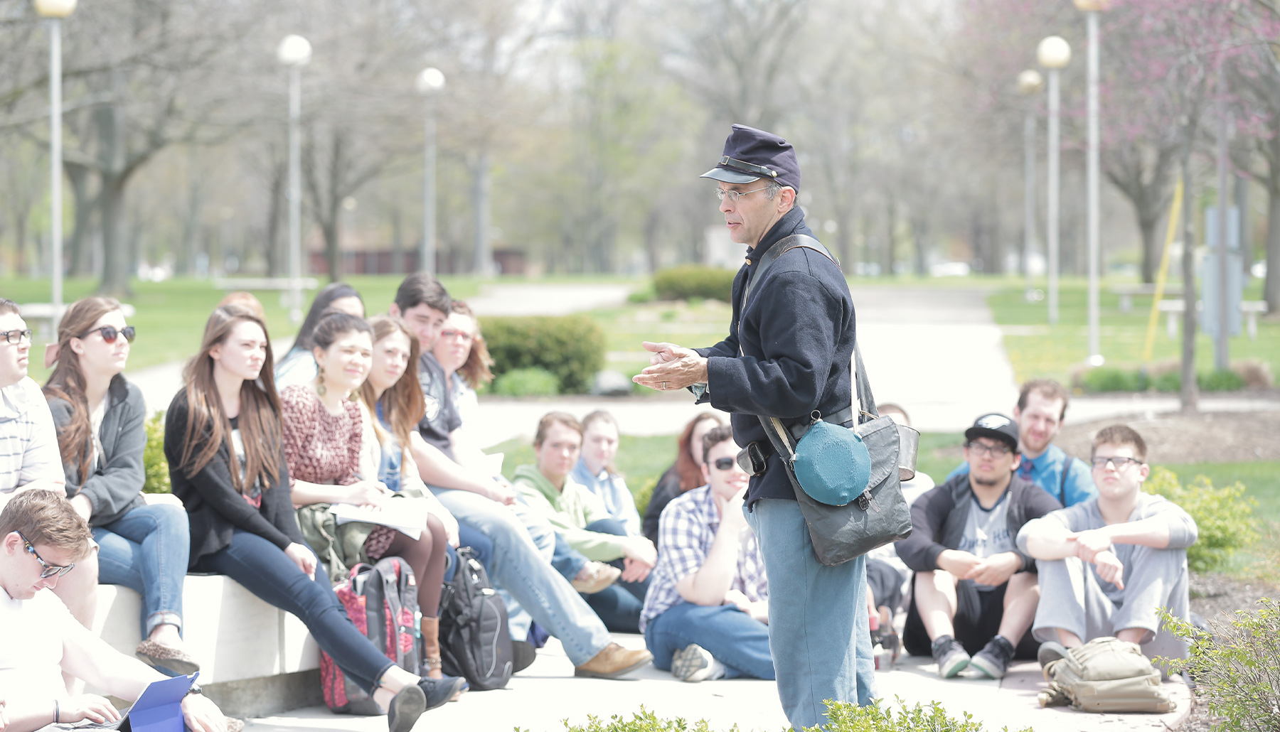 a professor dressed in civil war garb talks to students outdoors