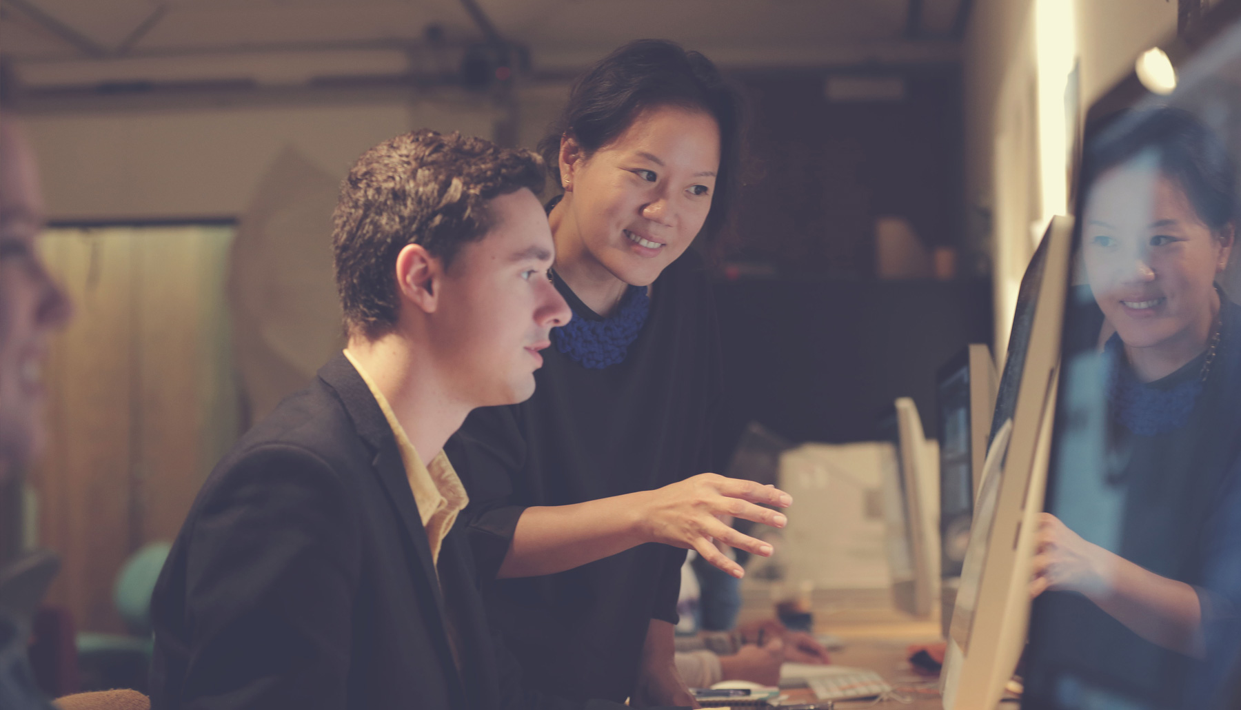 a professor works with a student at a computer