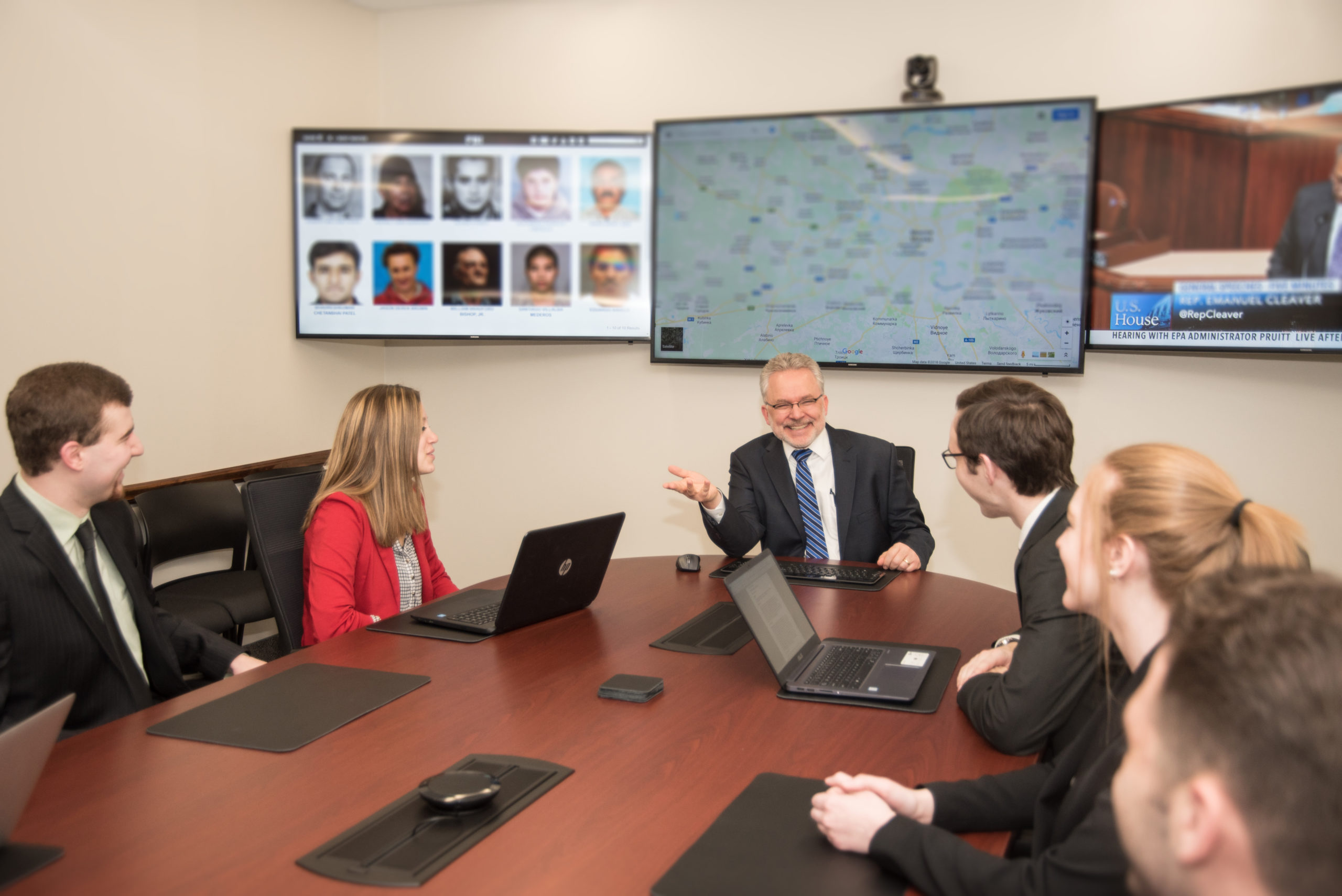 a male professor talks to five students in the situation room