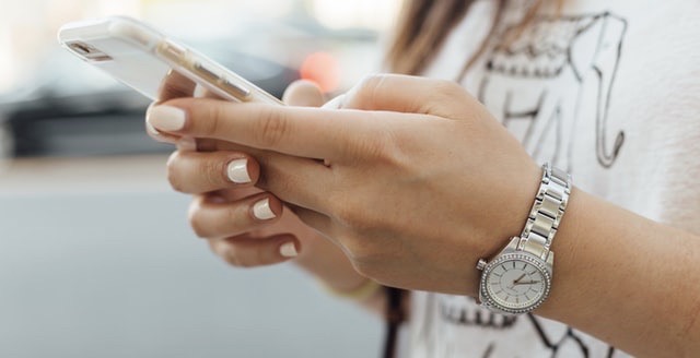 Paul Hanaoka HbyYFFokvm0 Unsplash Close view of hands holding an iPhone