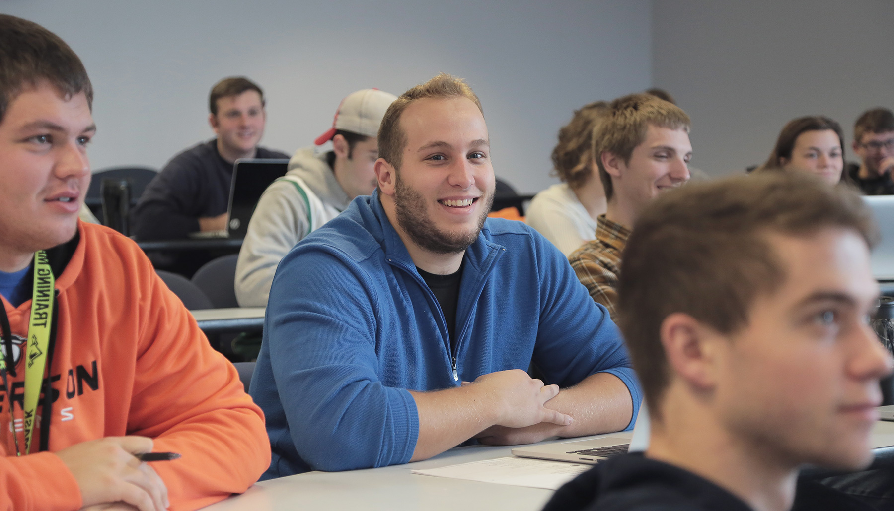a male student smiles in class