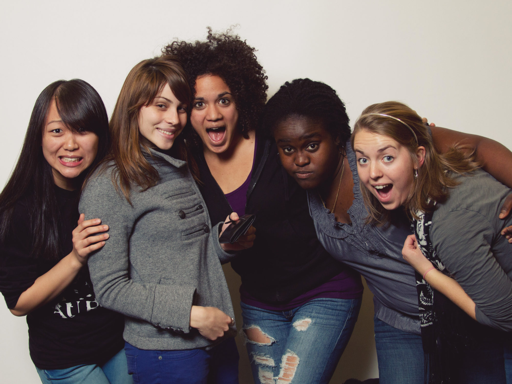 5 students posing for the camera with looks of shock and happy surprise